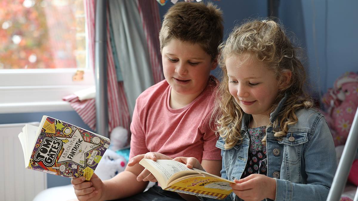 Brother and sister reading at home