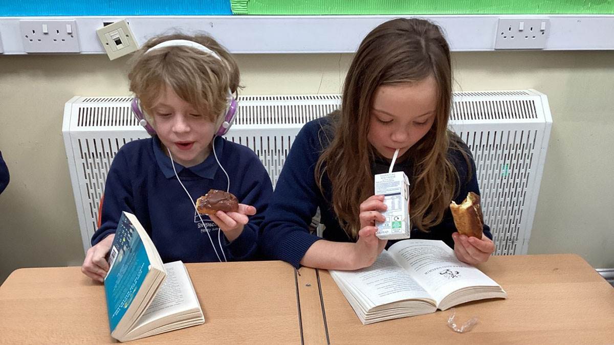 Children eating snacks and reading