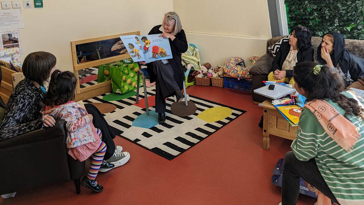 Debbie reading to a group of mums and their children