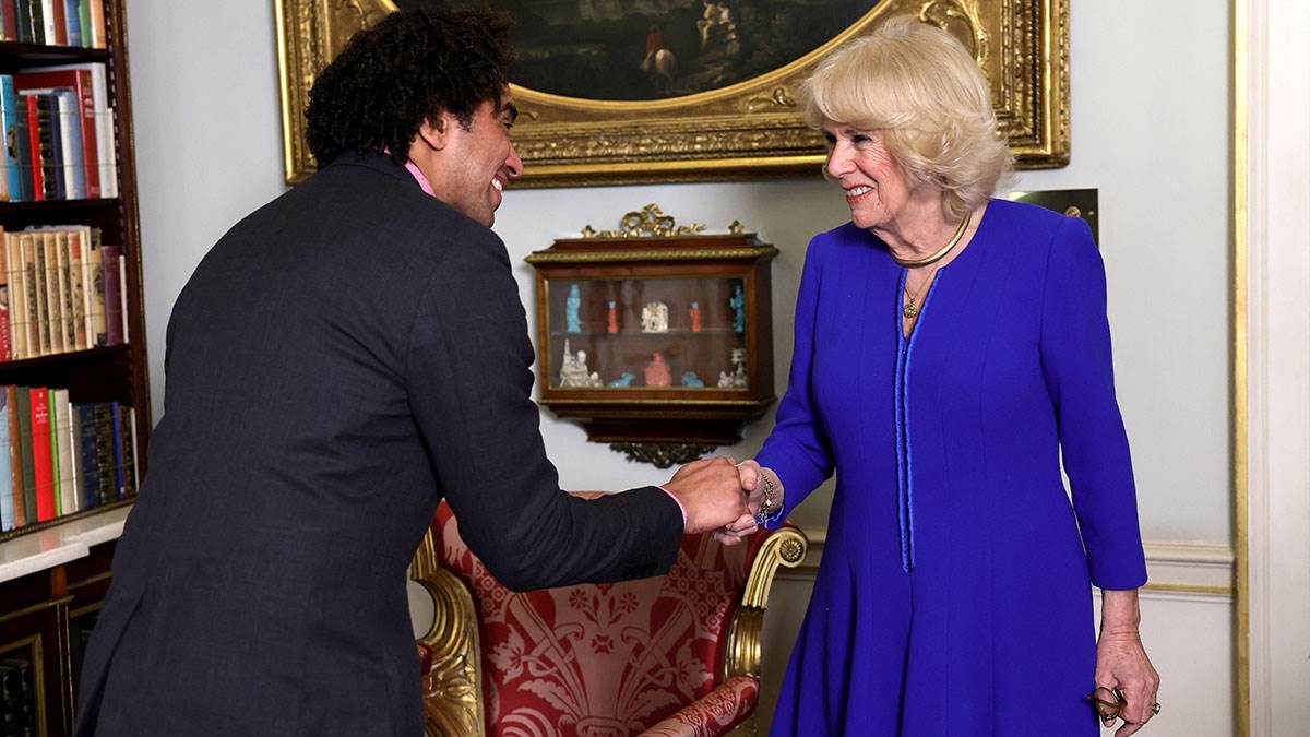 Children's Laureate Joseph Coelho meets Her Majesty The Queen Consort in the library at Clarence House