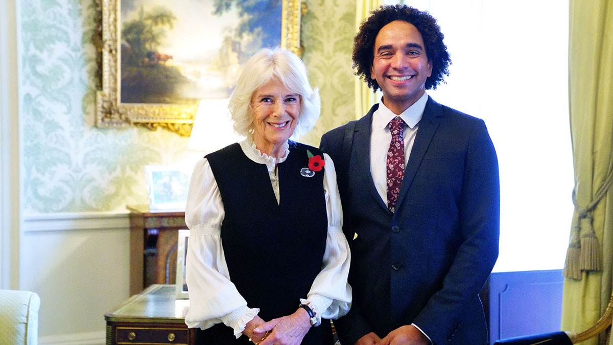 Camilla, Queen Consort of the United Kingdom and Waterstones Children's Laureate Joseph Coelho at Buckingham Palace