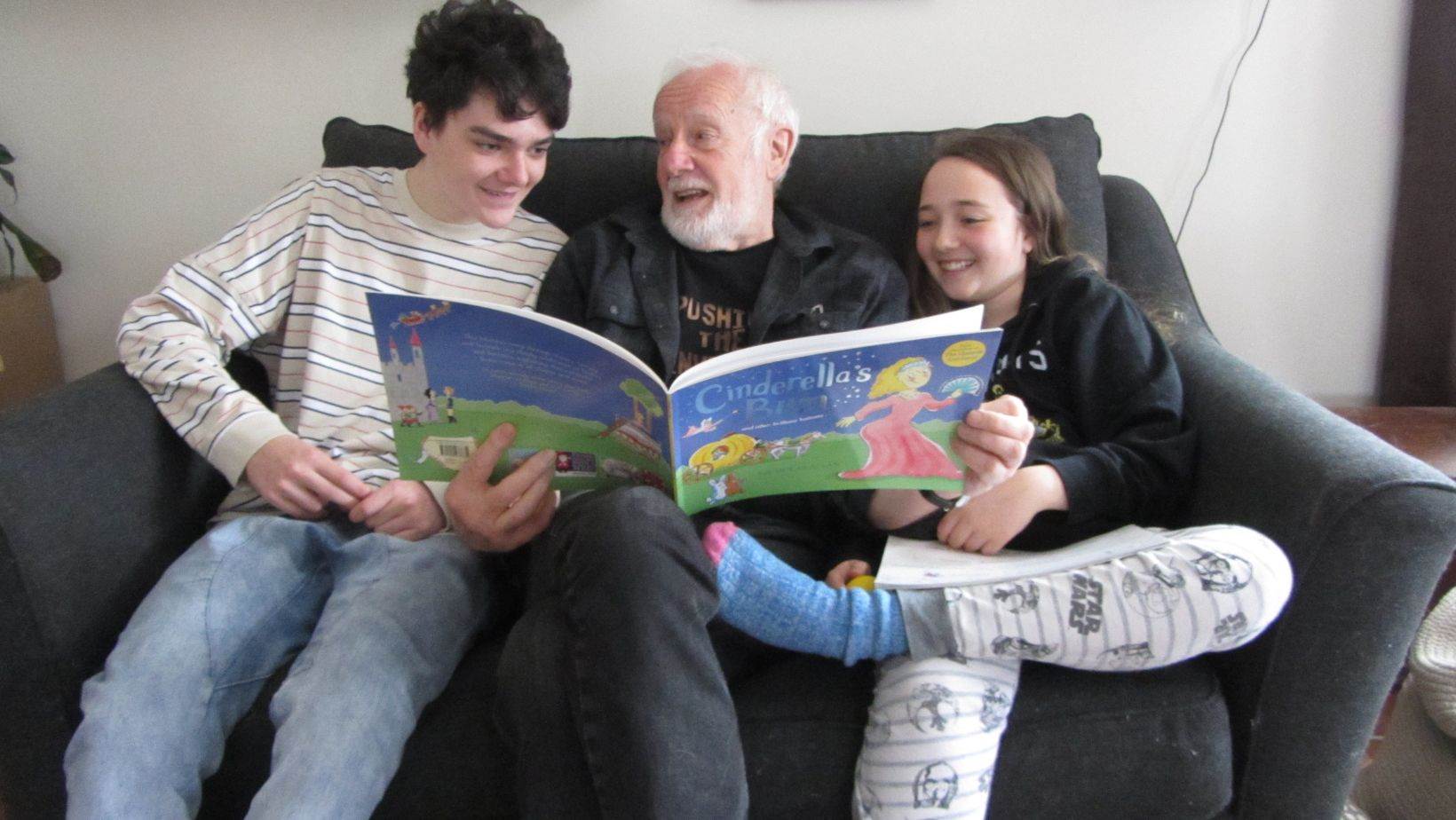 Peter Sheldon reading with his grandchildren