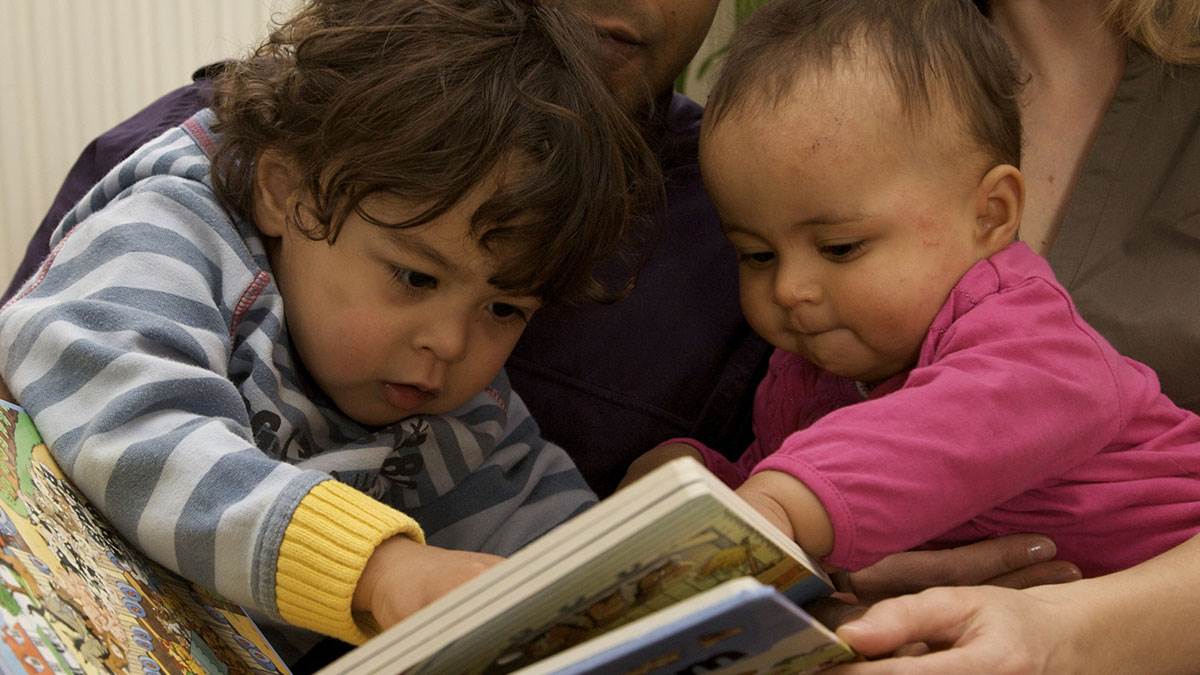 Two babies enjoy reading together