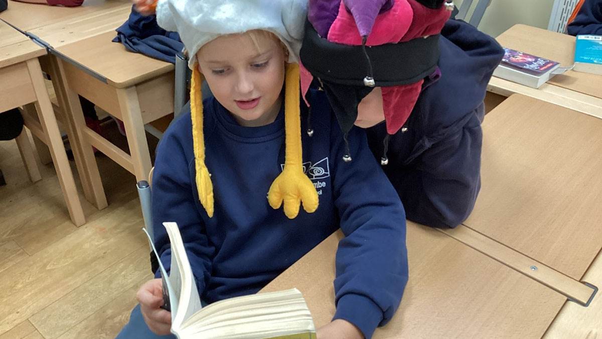 Children wearing hats and reading
