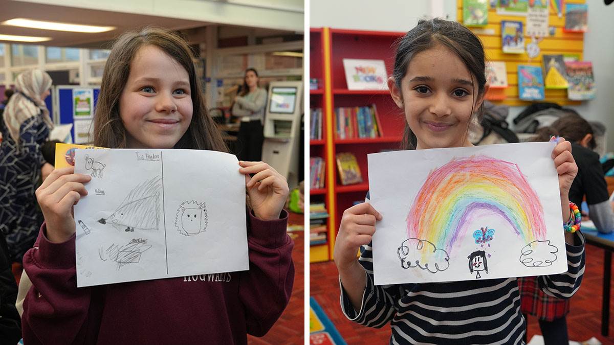Two children showing off their drawings at Uncle Brow Brows' event