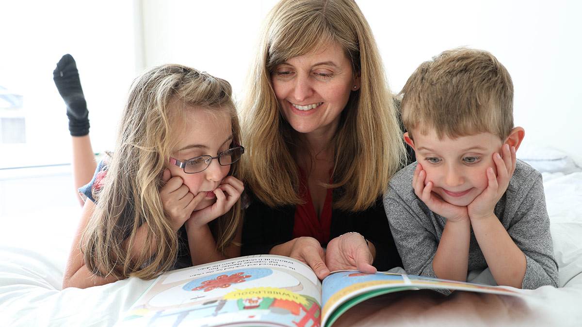 A mother and two children reading together