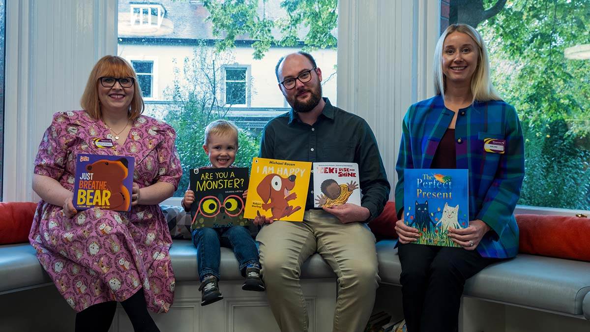 BookTrust NI's Chris Eisenstadt and his son with the BookTrust Storytime books, joined by Dr Mary-Ellen Lynn, Area Manager Belfast City and Aisling Press, District Officer Belfast City