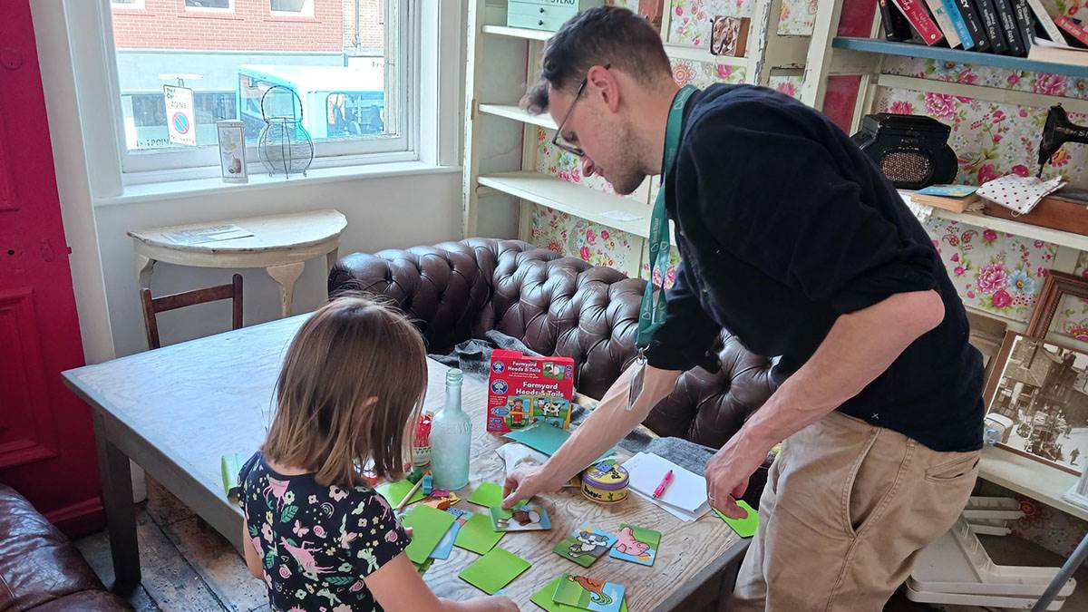 A BookTrust staff member playing an animal card game with a child at a Kinship workshop