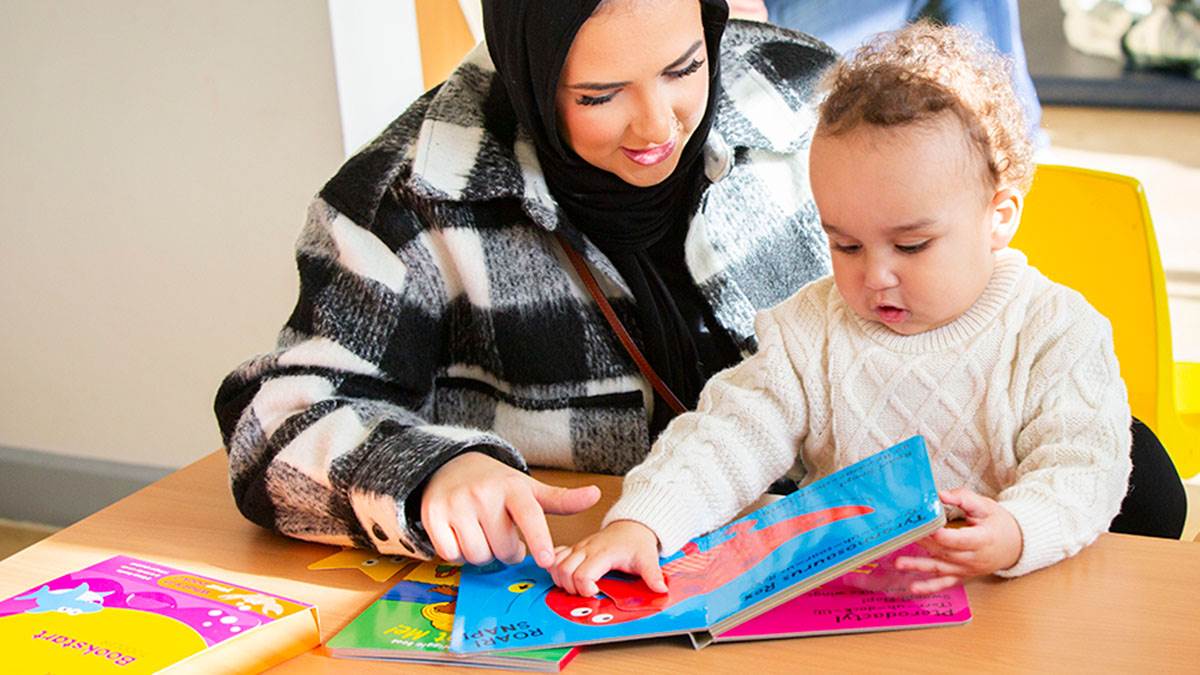 A photo of a woman and child sharing a Bookstart pack