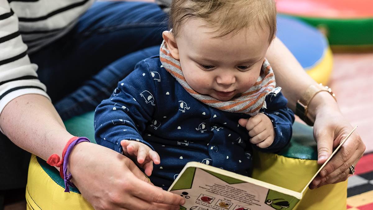Baby and mum sharing a book at a children's centre