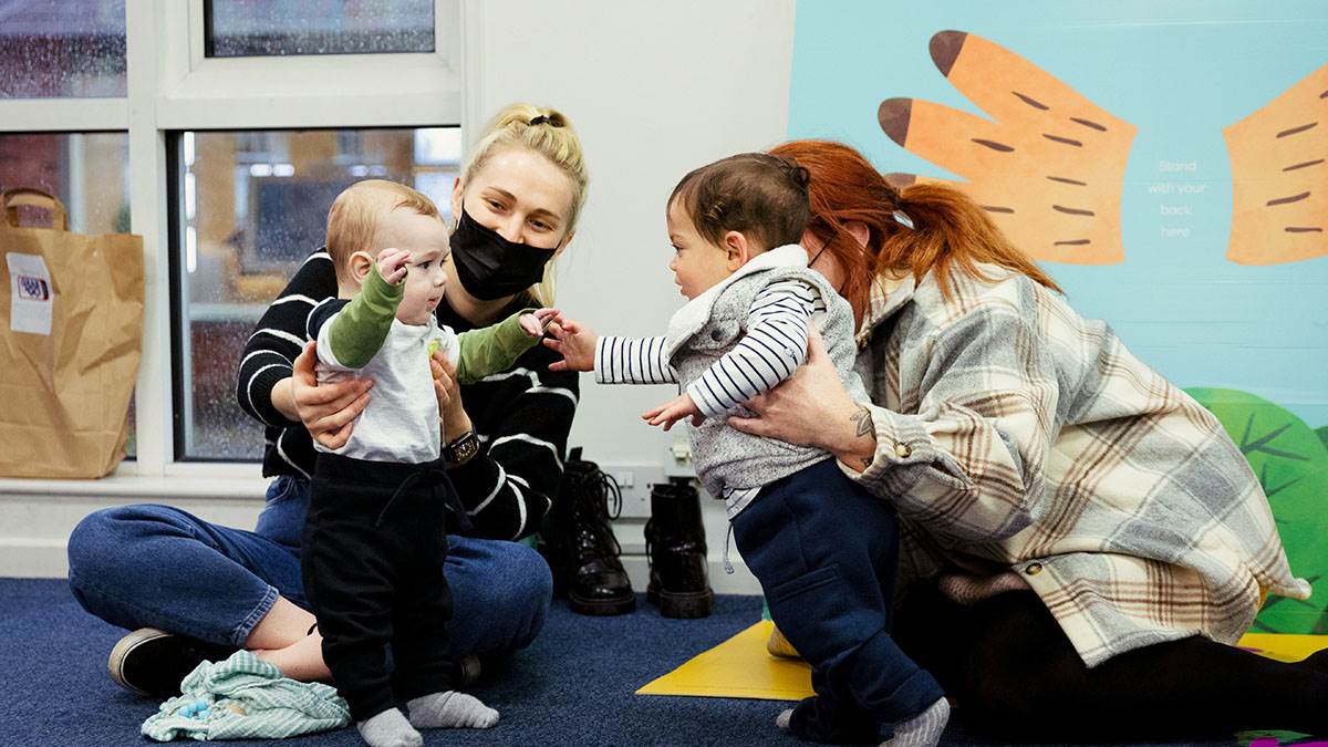 Two mums and their children playing together at a BookTrust Storytime event